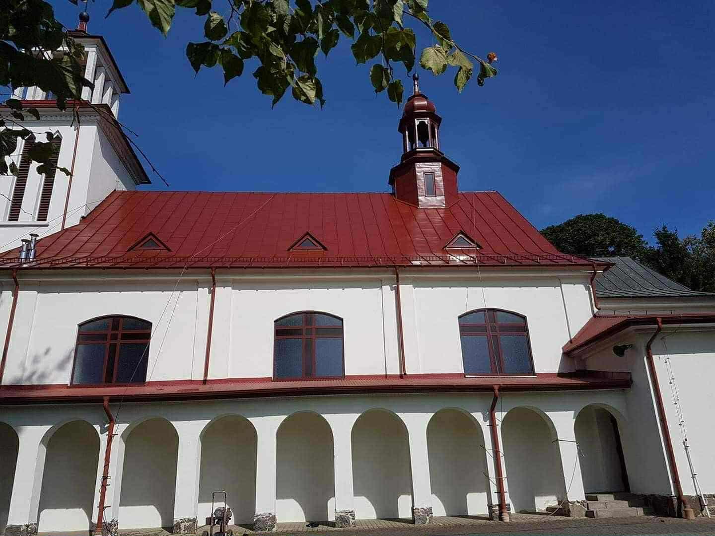 Kościół z odnowionym, czerwonym dachem blaszanym pomalowanym przez AKS-POL